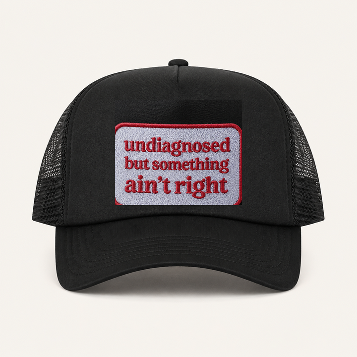 Black UNDIAGNOSED BUT SOMETHING AIN'T RIGHT trucker hat front view